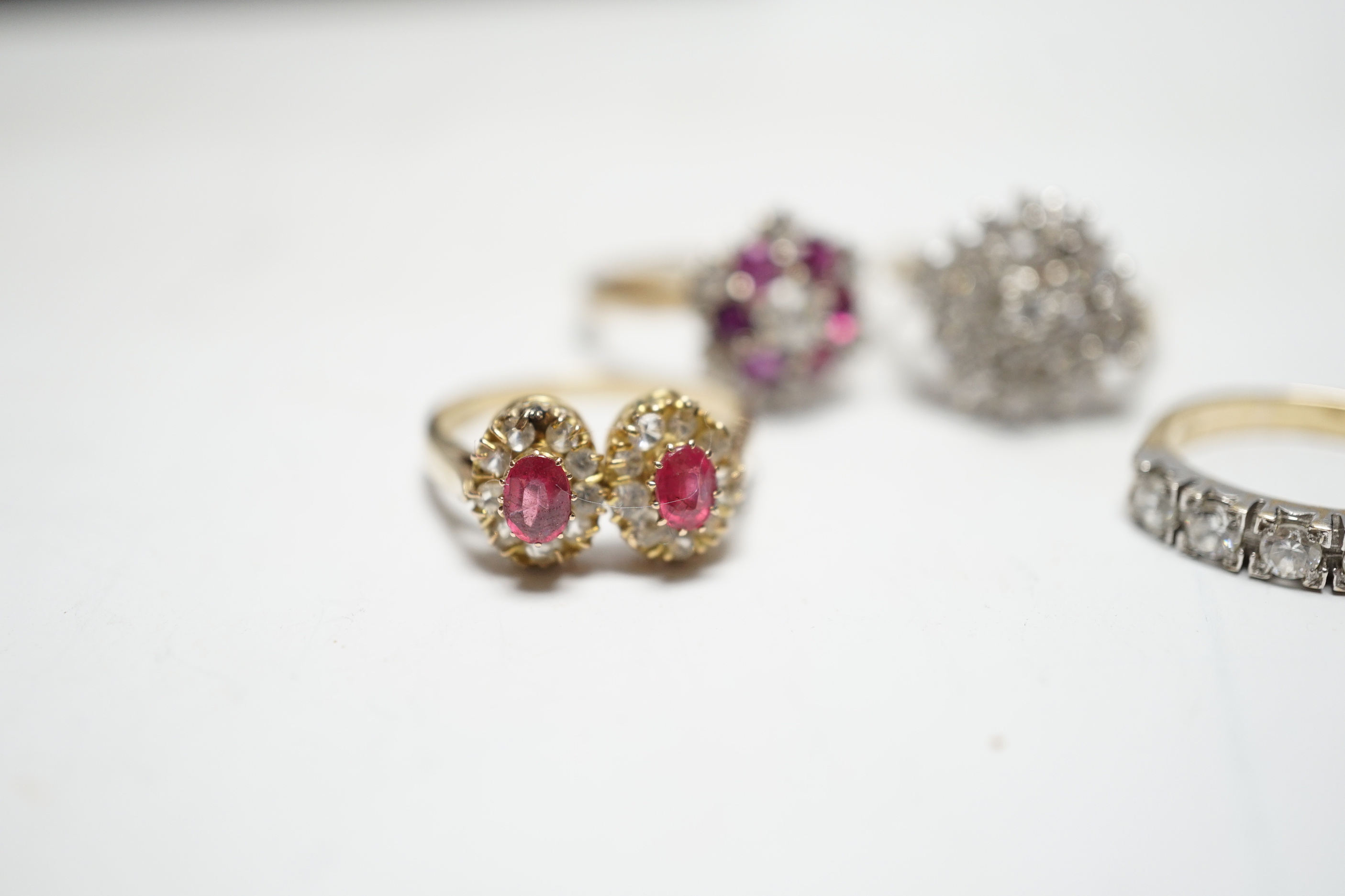 A modern 9ct gold, ruby and simulated diamond cluster set flower head ring, size N and three other assorted 9ct rings including CZ and two colour paste, gross weight 12.4 grams.